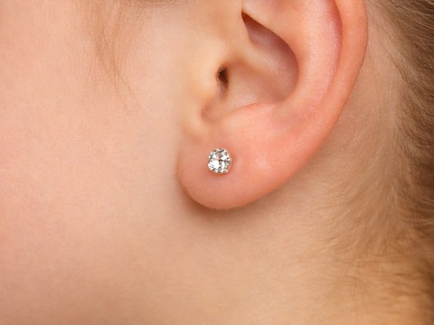 An earlobe wearing a purepixxi Flawless Crystal stud, calm and clear.